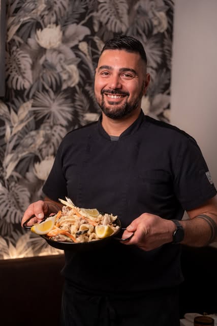 Lo chef di Osteria Le Cesarine con un piatto di mare